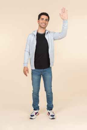 Young caucasian man smiling and waving