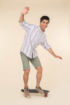 Smiling young caucasian guy standing on skate