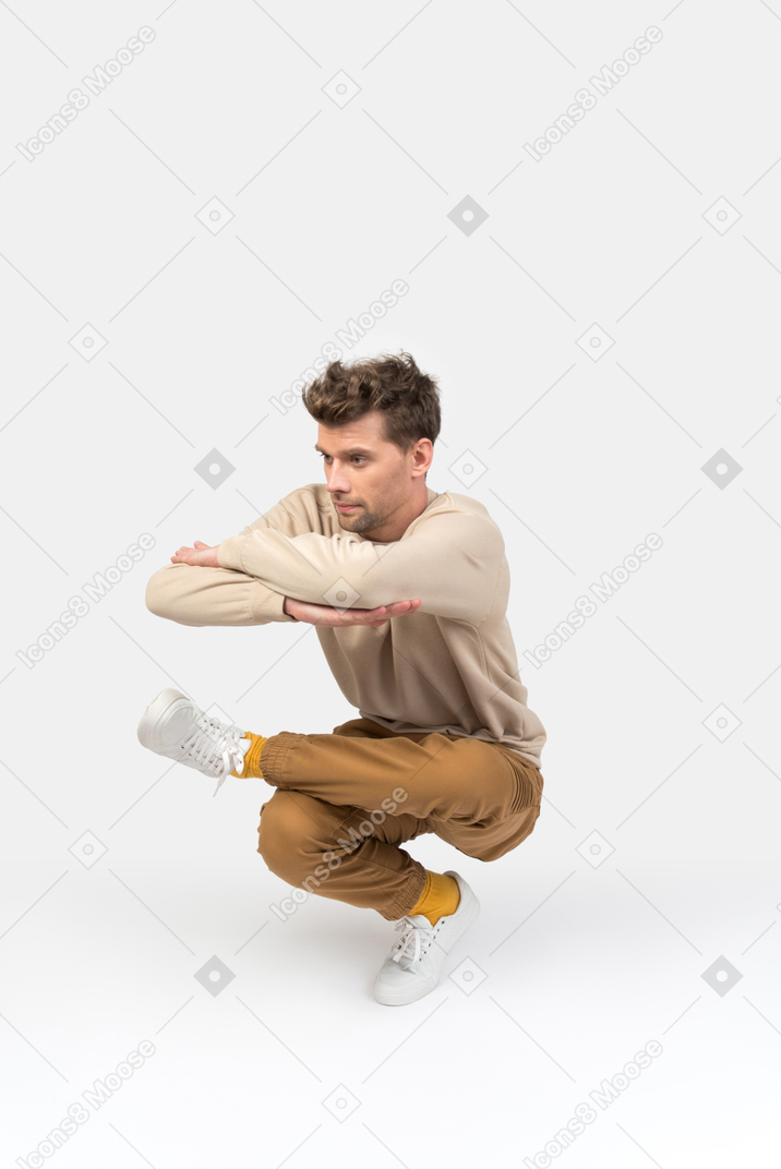 Giovane ragazzo seduto in posizione di danza hip-hop