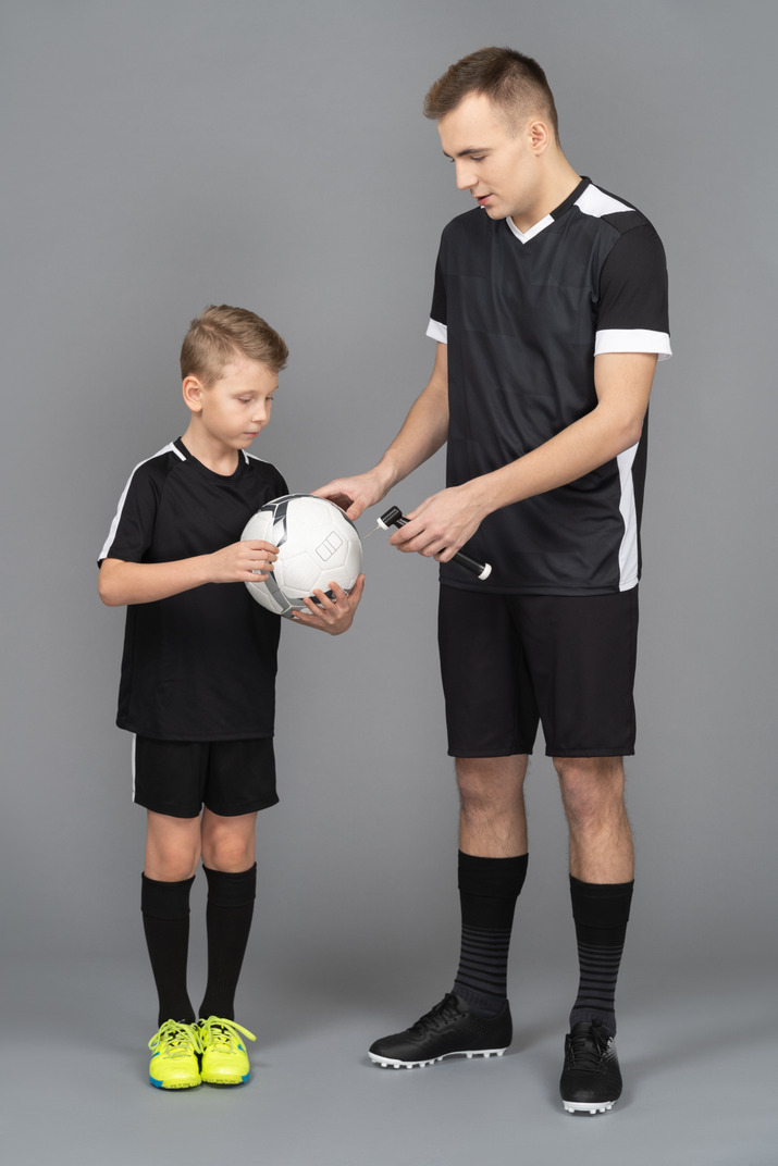 Full-length of a young man coaching little boy