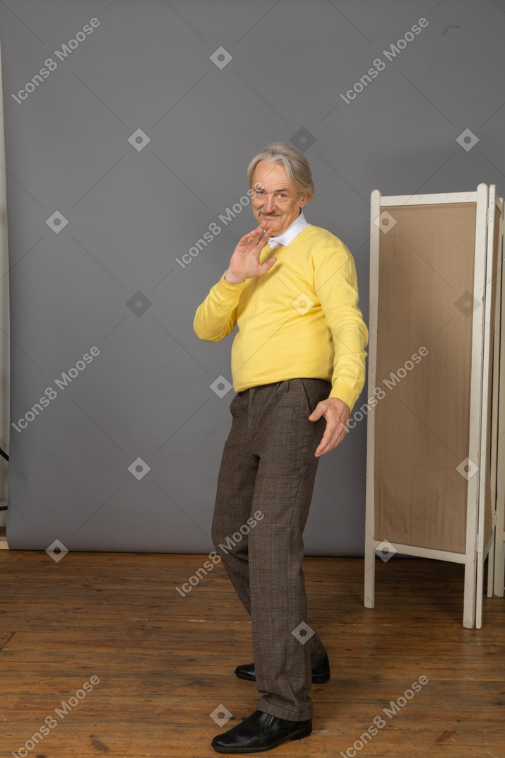 Vue de trois quarts d'un vieil homme souriant dansant