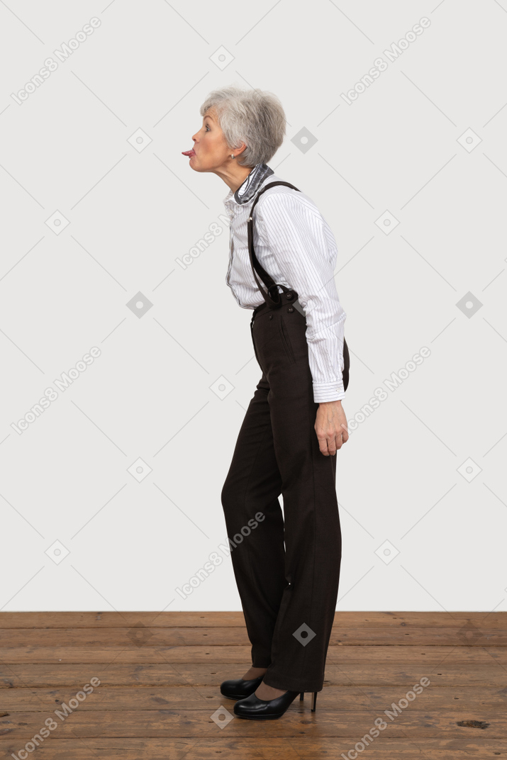 Side view of a crazy old lady in office clothing leaning forward