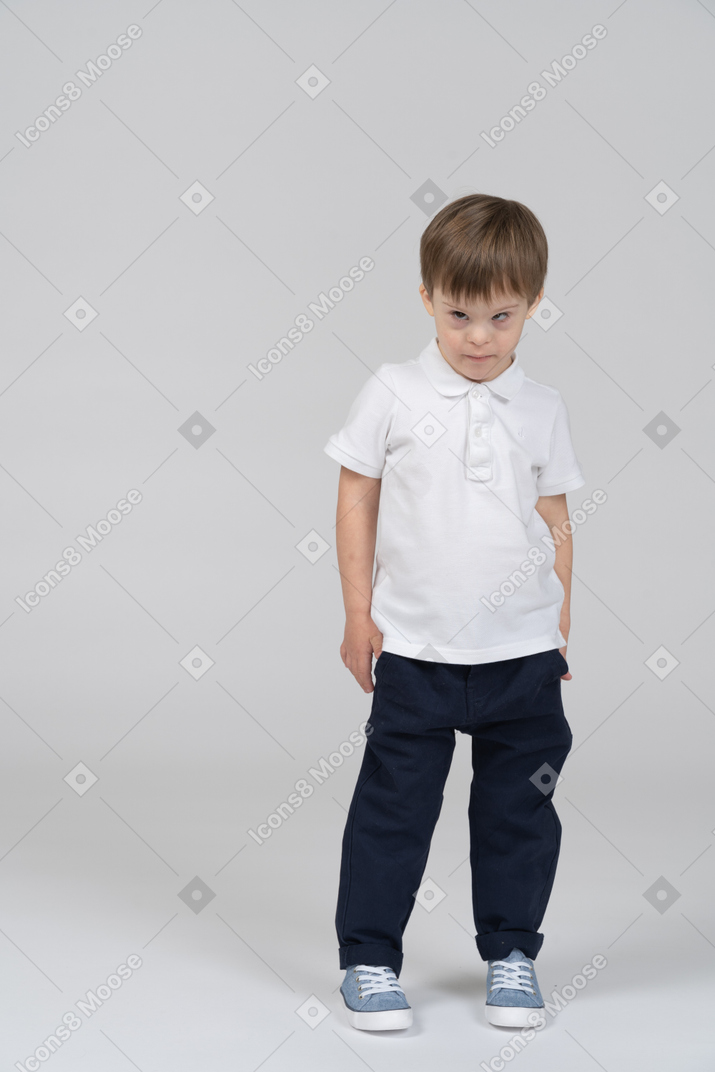 Little boy standing still with arms at side