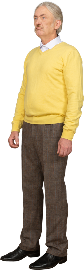 Three-quarter view of a displeased old man wearing yellow pullover and looking up