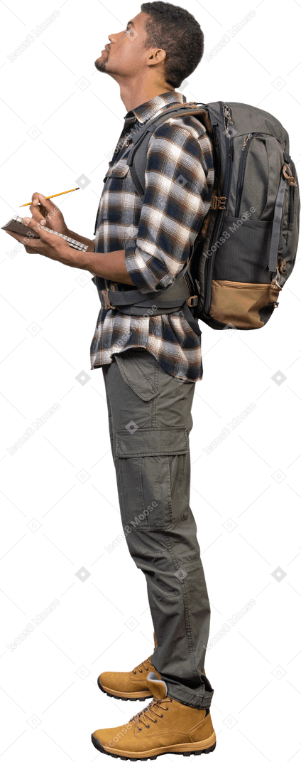 Vista lateral de um turista com uma mochila e um bloco de notas