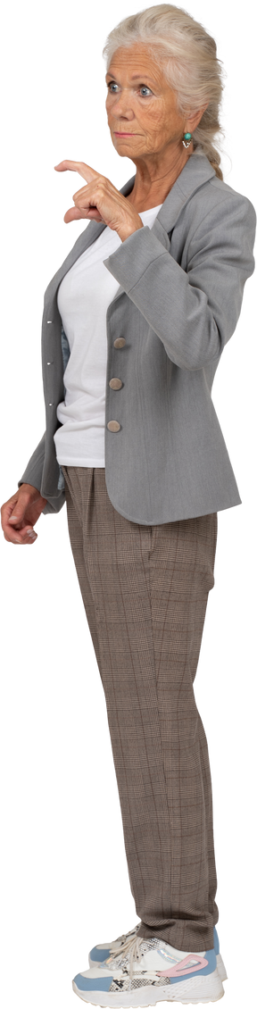 Vista lateral de una anciana en traje mostrando el tamaño pequeño de algo