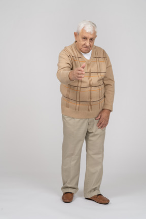 Вид спереди на старика в повседневной одежде, протягивающего руку для рукопожатия