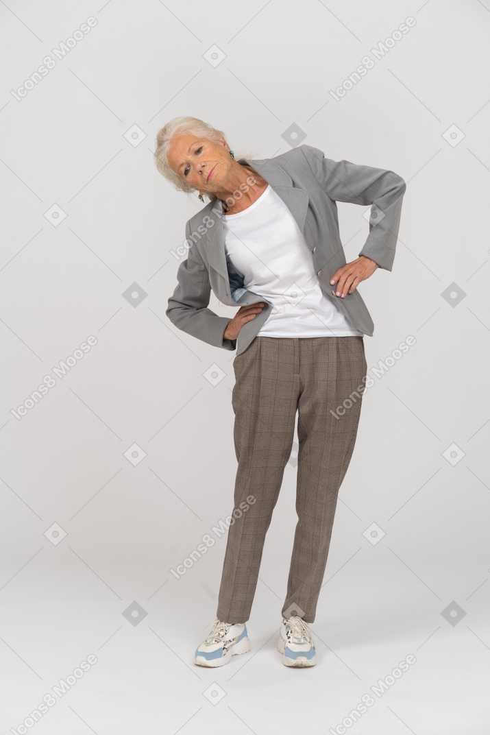 Front view of an old lady in suit stretching
