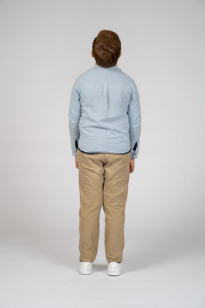 Rear view of a boy in casual clothes looking up