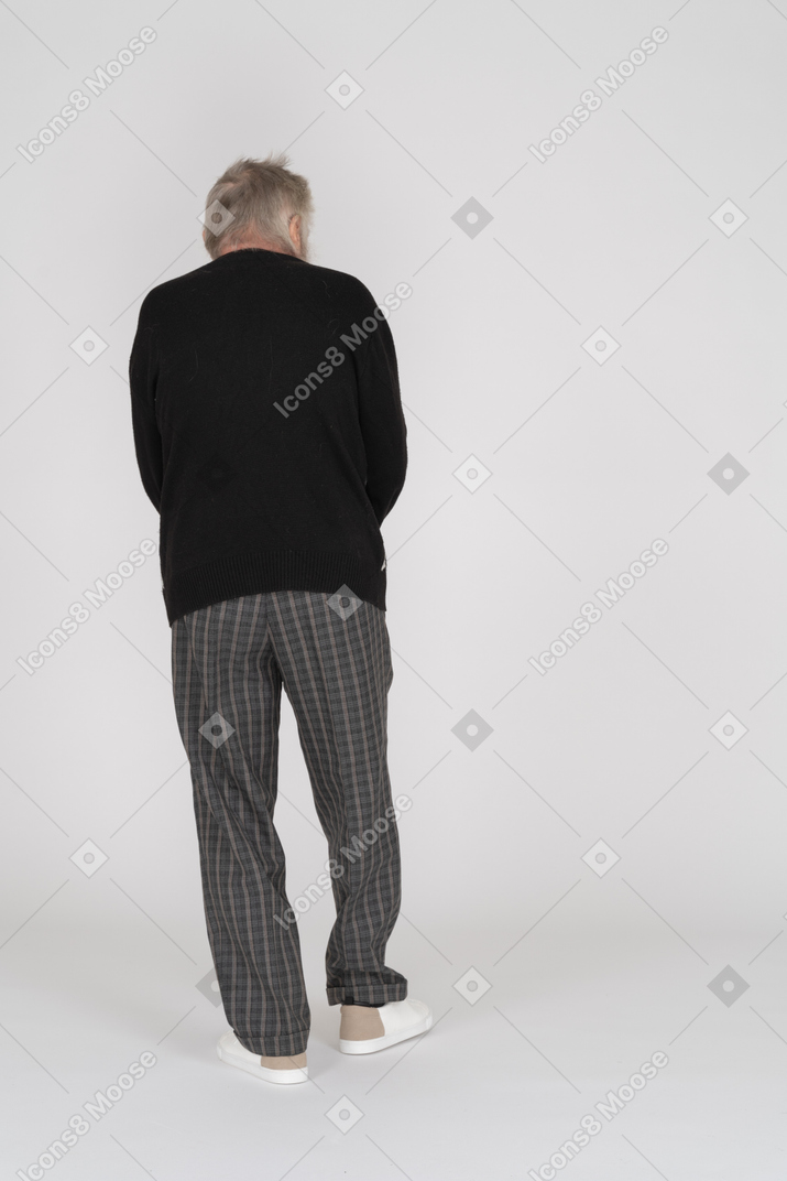 Homem idoso em pé de costas para a câmera