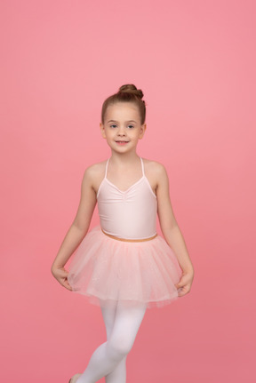 Petite ballerine tenant tutu avec ses mains