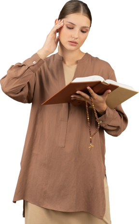 Mujer joven tocando su templo mientras lee el libro