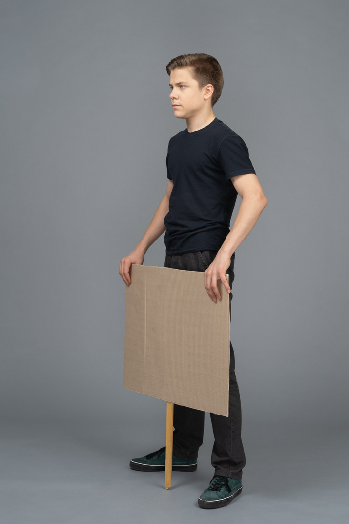 Serious young man standing with a blank  poster