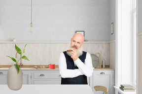 A man standing in a kitchen with a cup of coffee