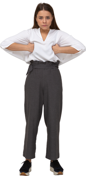 Front view of a young lady in office clothing putting hands on chest