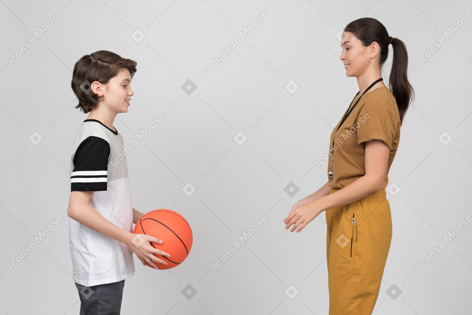 Pe female teacher and pupil practicing basketball technique