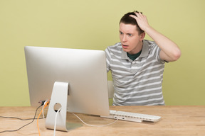 Terrified young man touching his head