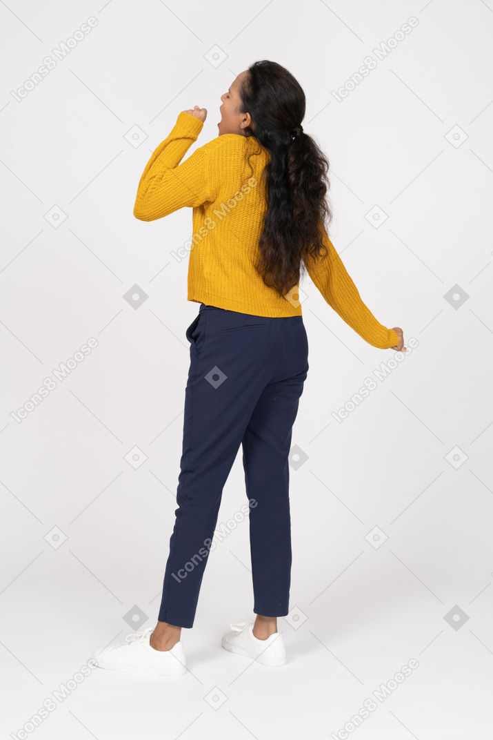 Rear view of a girl in casual clothes yawning and stretching