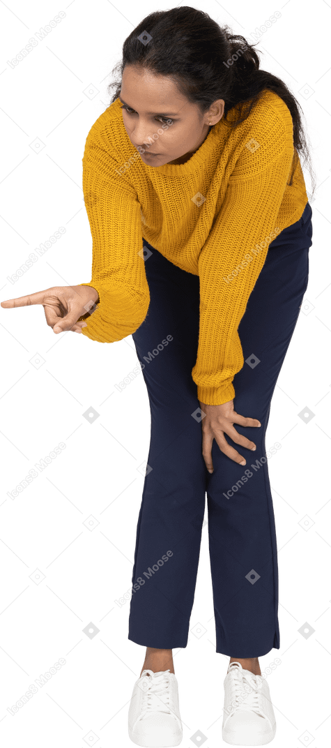 Front view of a girl in casual clothes bending down and making warning sign