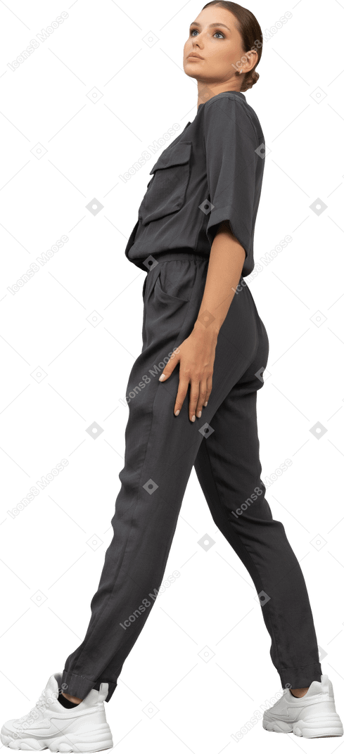 Side view of a bossy young woman in a jumpsuit