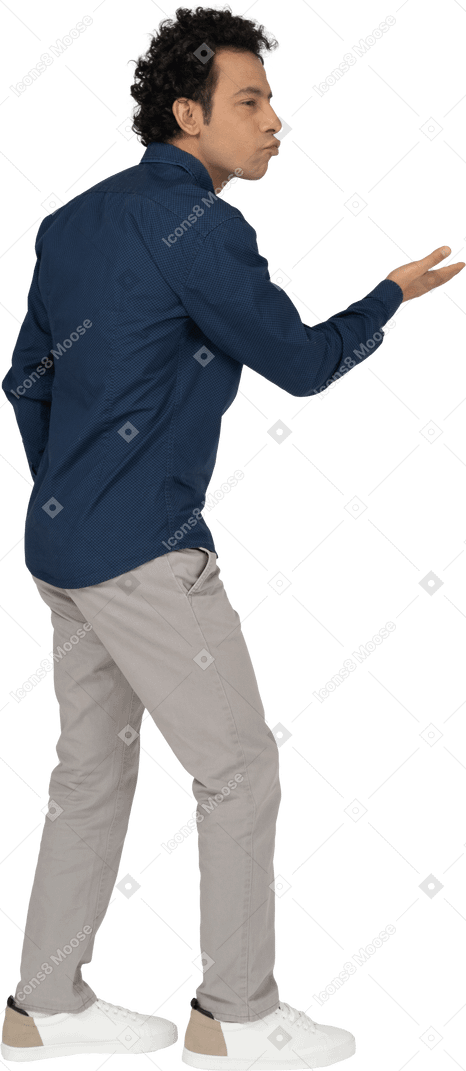 Vista lateral de un hombre en ropa casual enviando besos al aire