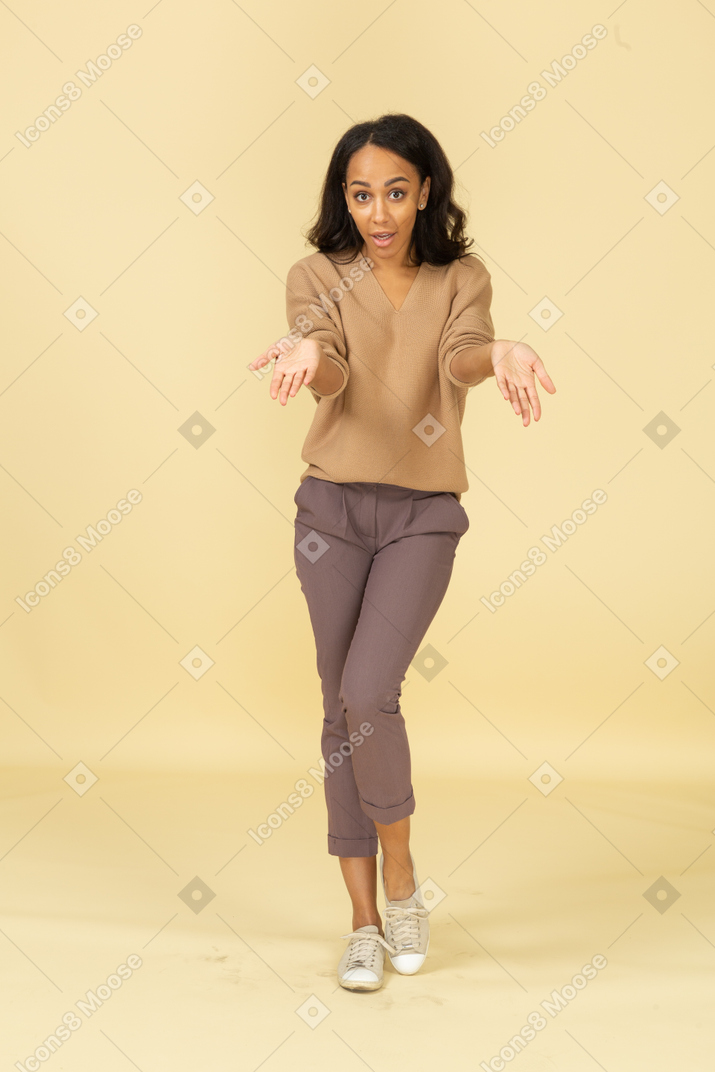 疑问的皮肤黝黑的年轻女性，伸出来的手的前视图