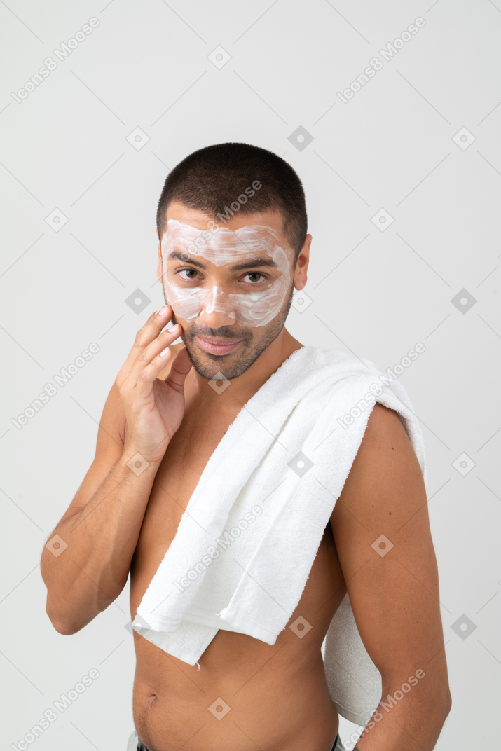 A man with a towel on his shoulder and a face mask on
