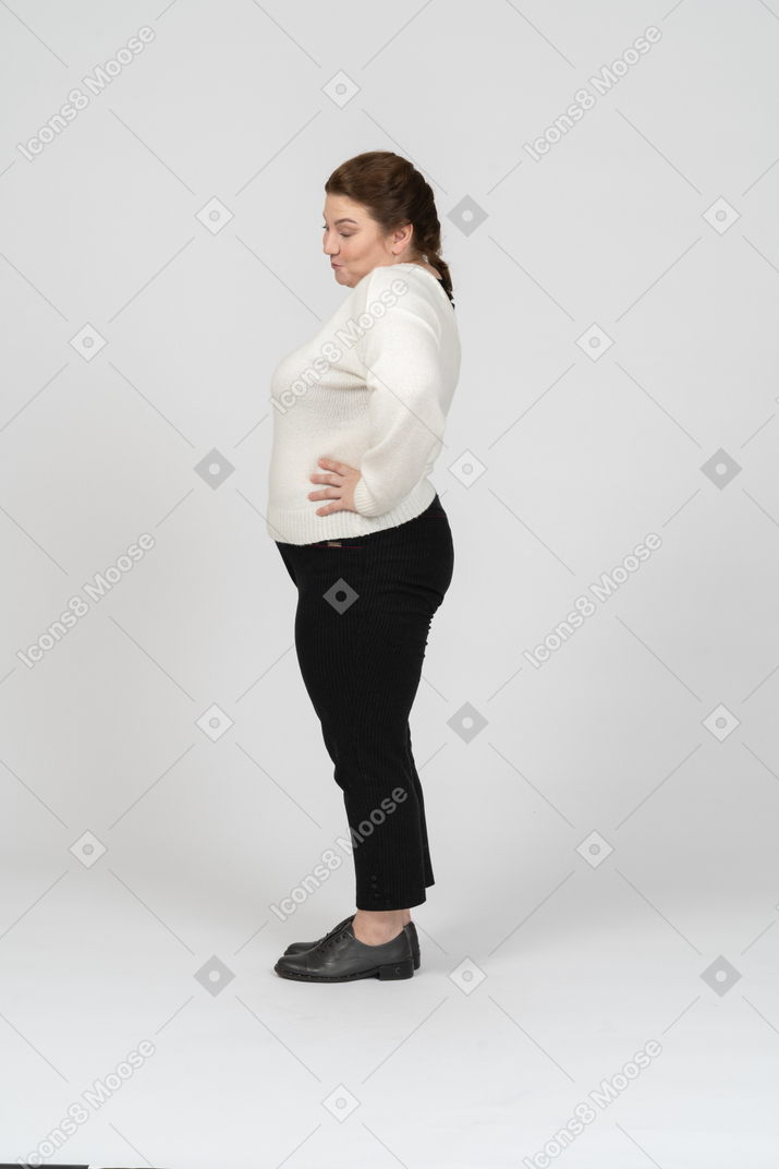 一个穿着休闲服摆姿势的胖女人的侧视图