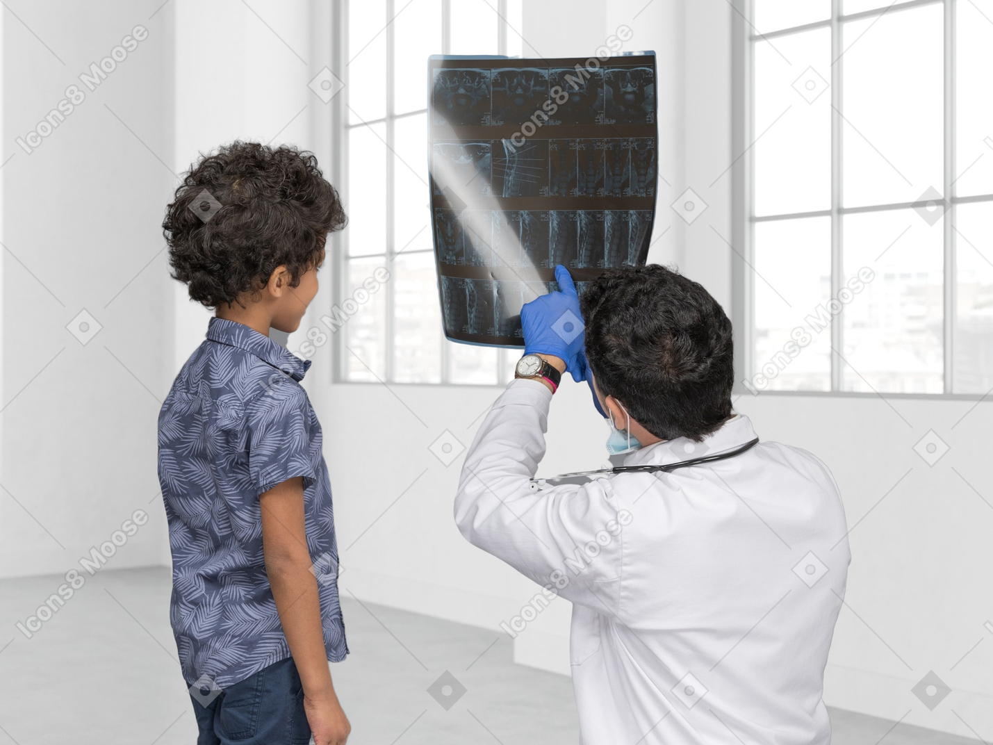 Médico que muestra una imagen de rayos x a un pequeño paciente