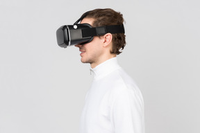 Side view of young smiling man in virtual reality headset