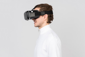 Seitenansicht eines jungen lächelnden mannes im virtual-reality-headset