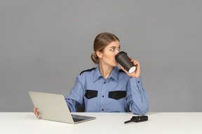 A female security guard drinking a coffee