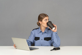 Una mujer guardia de seguridad tomando un café