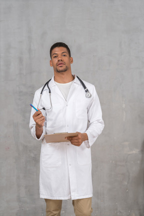 A male doctor holding a clipboard