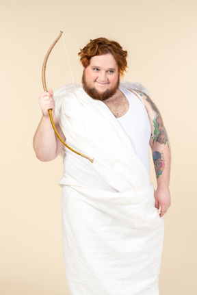 Big guy dressed as a cupid holding bow