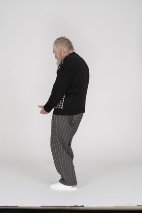 Side view of old man crouching and gesturing