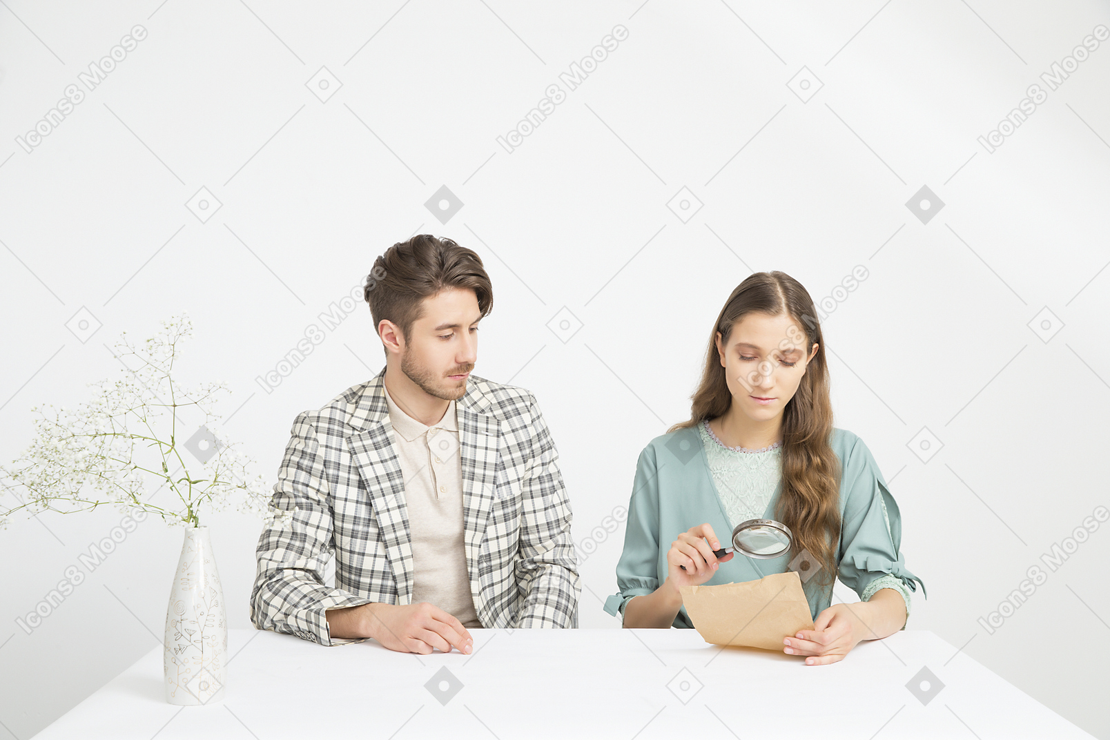 Пара сидит за столом и исследует газету
