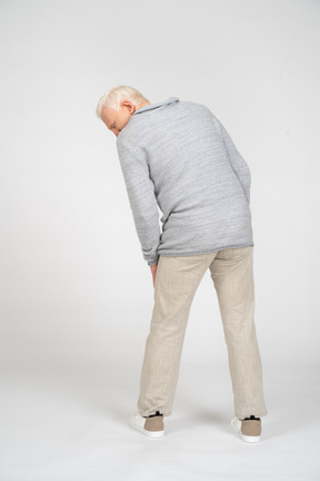 Back view of a man standing and bending over