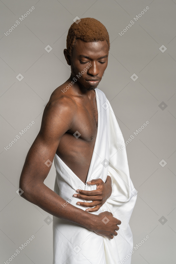 Side view of a young man in white towel