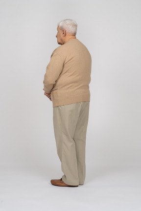 Side view of an old man in casual clothes standing still