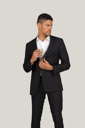 Vorderansicht eines jungen mannes im schwarzen anzug mit bankkarte