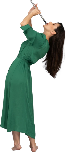 Side view of a young lady in green dress playing flute while leaning back