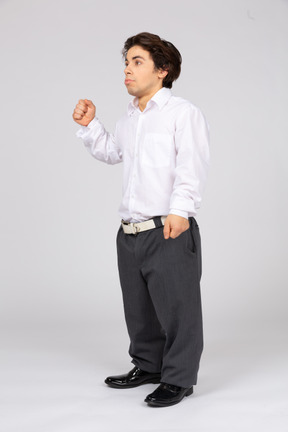 Confused young man raising fist