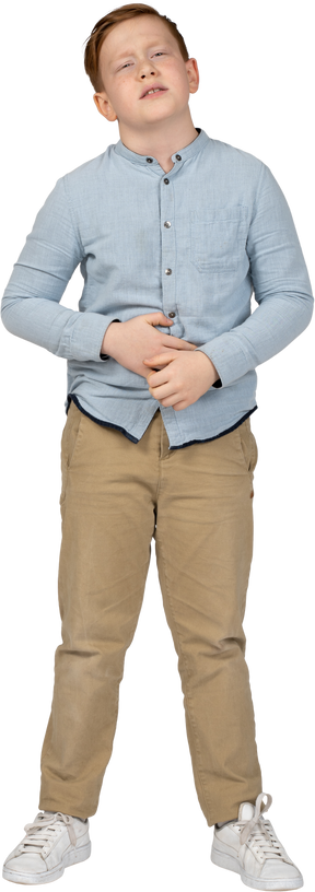 Vista frontal de un niño que sufre de dolor de estómago