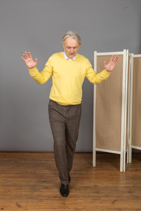 Vista frontal de um homem idoso que anda se equilibrando