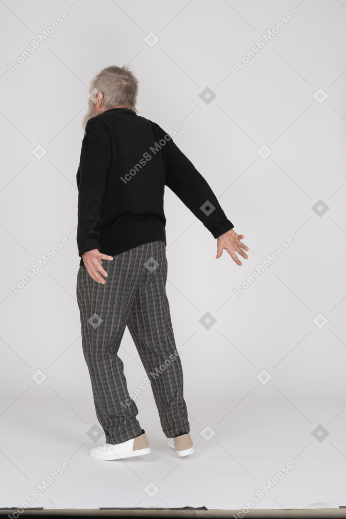 Homme âgé debout, les bras tendus vers l'arrière