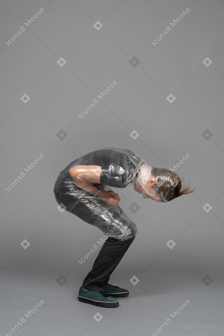 Side view of a boy wrapped in plastic