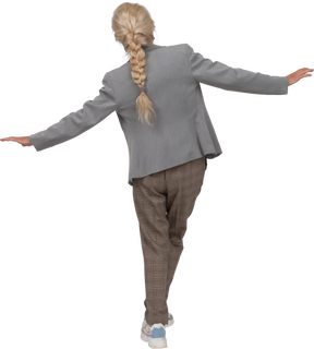 Vista traseira de uma senhora idosa de terno em pé com os braços estendidos