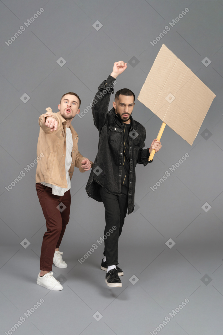 Front view of two young men with a billboard looking outraged