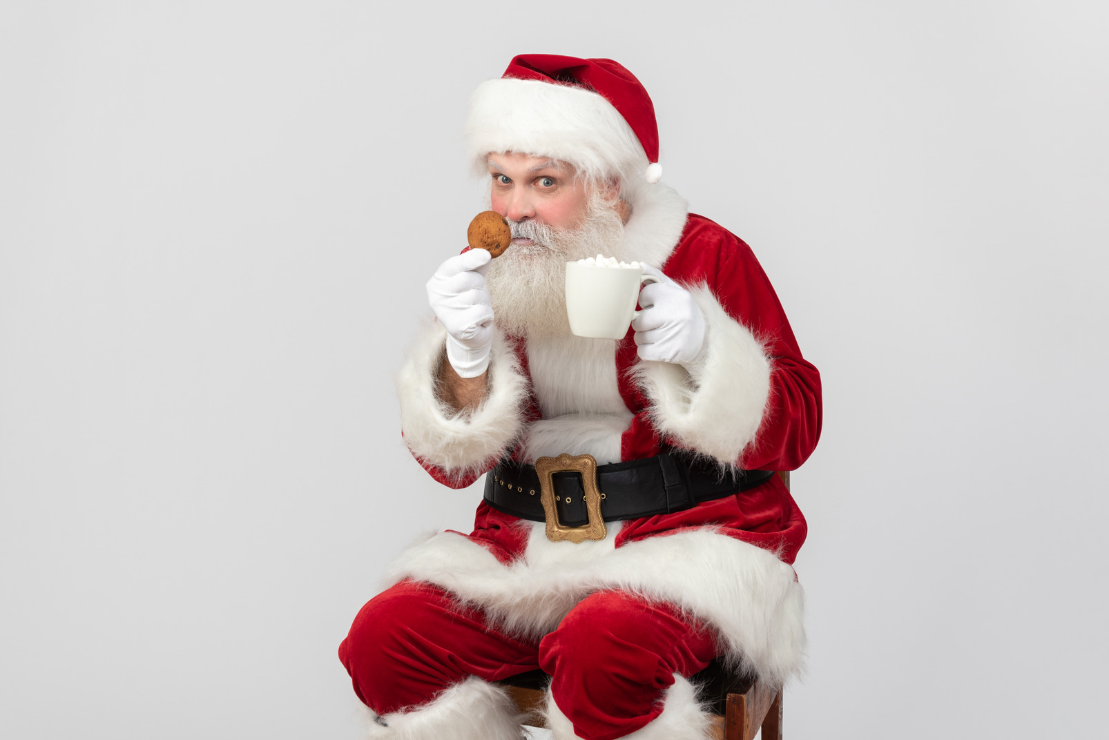 Santa claus drinking tea and holding cookie